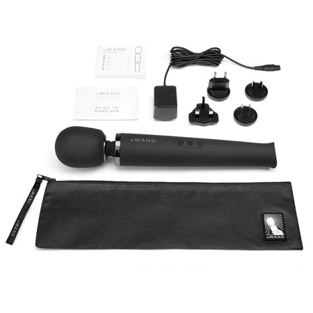 A black Le Wand rechargeable vibrating massager with a wired remote control and various accessories, including a silicone head, neck flex, and a black textured cover.