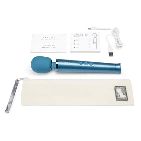 The image shows a blue Le Wand Petite Rechargeable Massager along with a USB charging cable, a travel lock, a travel case, and a pleasure guide.