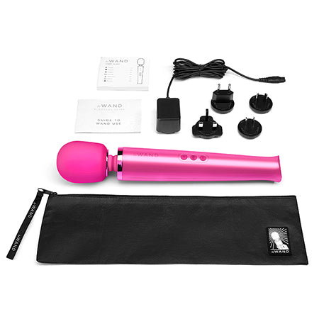 The image shows a magenta Le Wand Rechargeable Vibrating Massager with a sleek design, including a body-safe silicone head, a flexible neck, a charging unit, and a black travel case with a zipper.