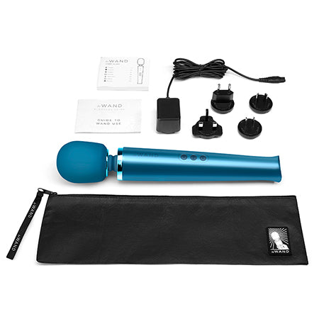 The image shows a Pacific Blue Le Wand Rechargeable Vibrating Massager along with a black travel case, a charging cable, and a control panel. The massager has a sleek, curved design with a blue accent.