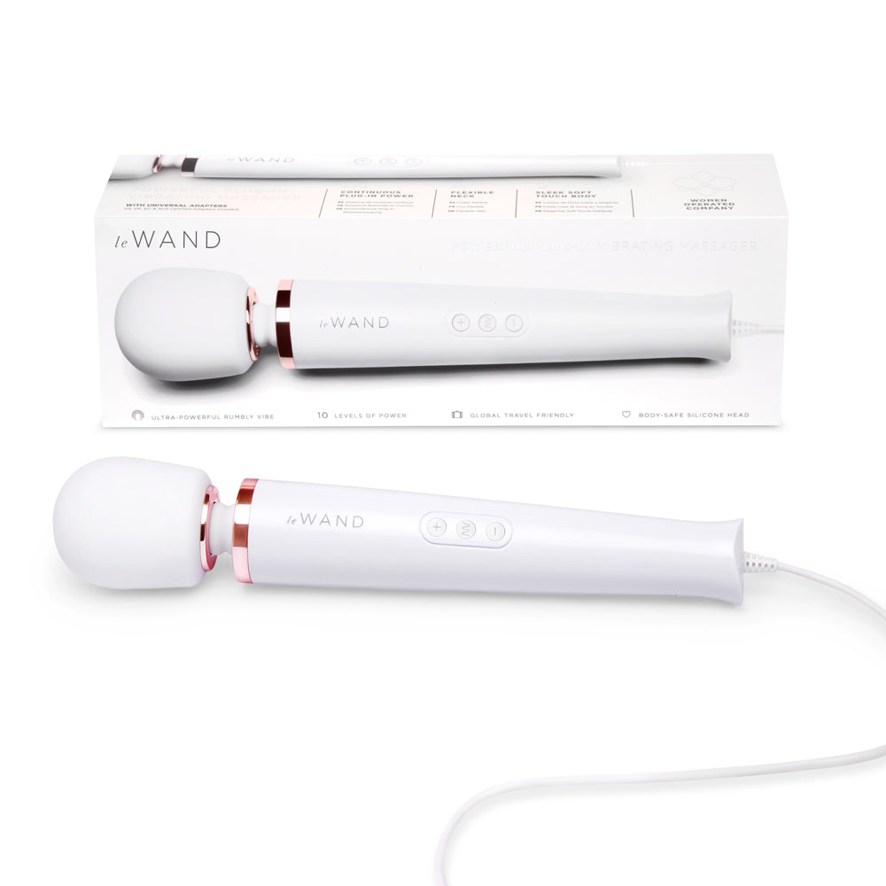 A white Le Wand Plug-In Vibrating Massager with a flexible neck and a control panel. The product is shown both inside its packaging and separately.