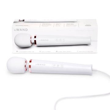A white Le Wand Plug-In Vibrating Massager with a flexible neck and a control panel. The product is shown both inside its packaging and separately.