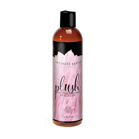 A bottle of Intimate Earth Plush Hybrid Anal Glide with a pink label and cap, indicating it is a thick anal lubricant.