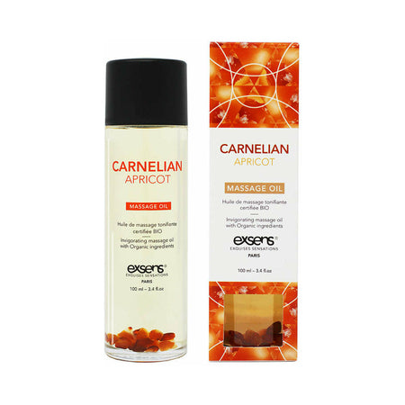 A bottle and box of Exsens Massage Oil with Carnelian Apricot scent. The packaging is predominantly white and orange with images of apricots and a crystal.