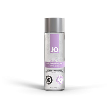 Bottle of JO Agape Water-Based Lubricant with a purple label, clear liquid visible inside the bottle, designed for sensitive skin.